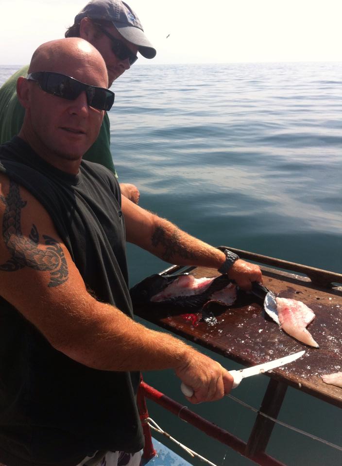 A Crew member of the MV Skipper cleaning your fish!